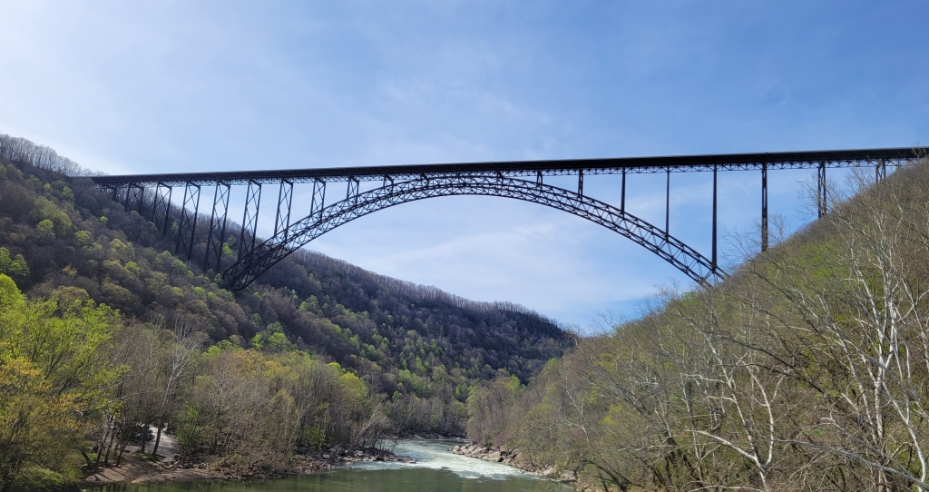 A view of a bridge with an incredible arch that spans across a huge gorge.