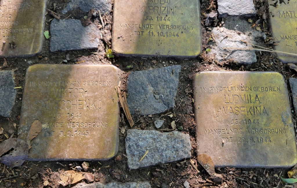 A detail view of seven stones with inscriptions and names on them as part of a Holocaust memorial.