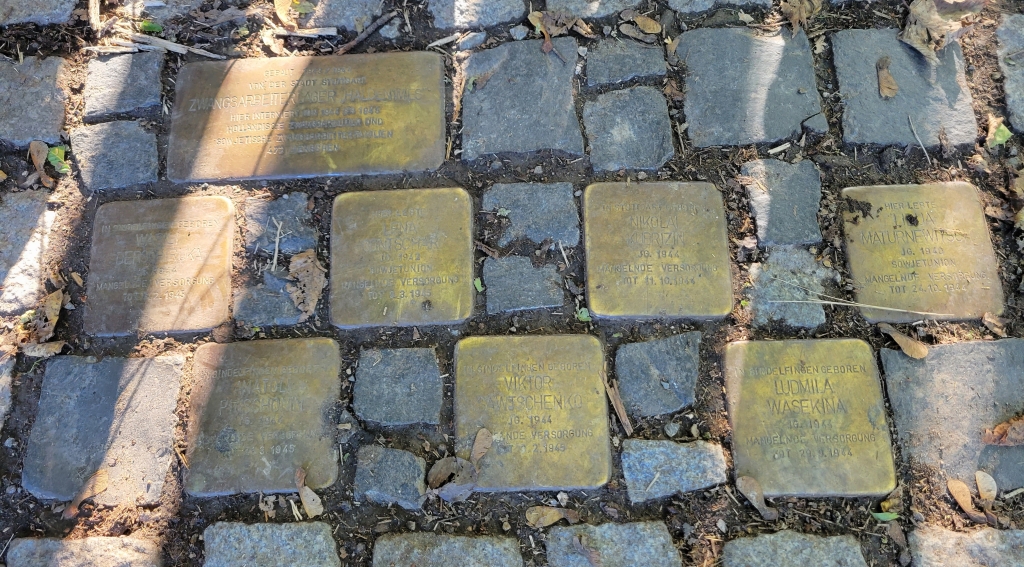 Seven square stones and one rectangular one in the ground with various inscriptions.